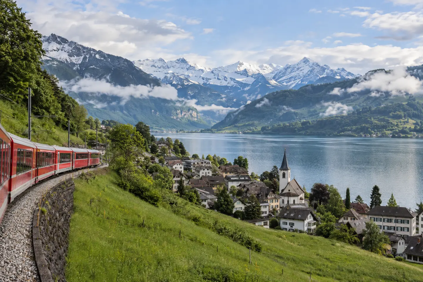 Editorial view of an Alpine lake, mountain railway and Swiss-style village