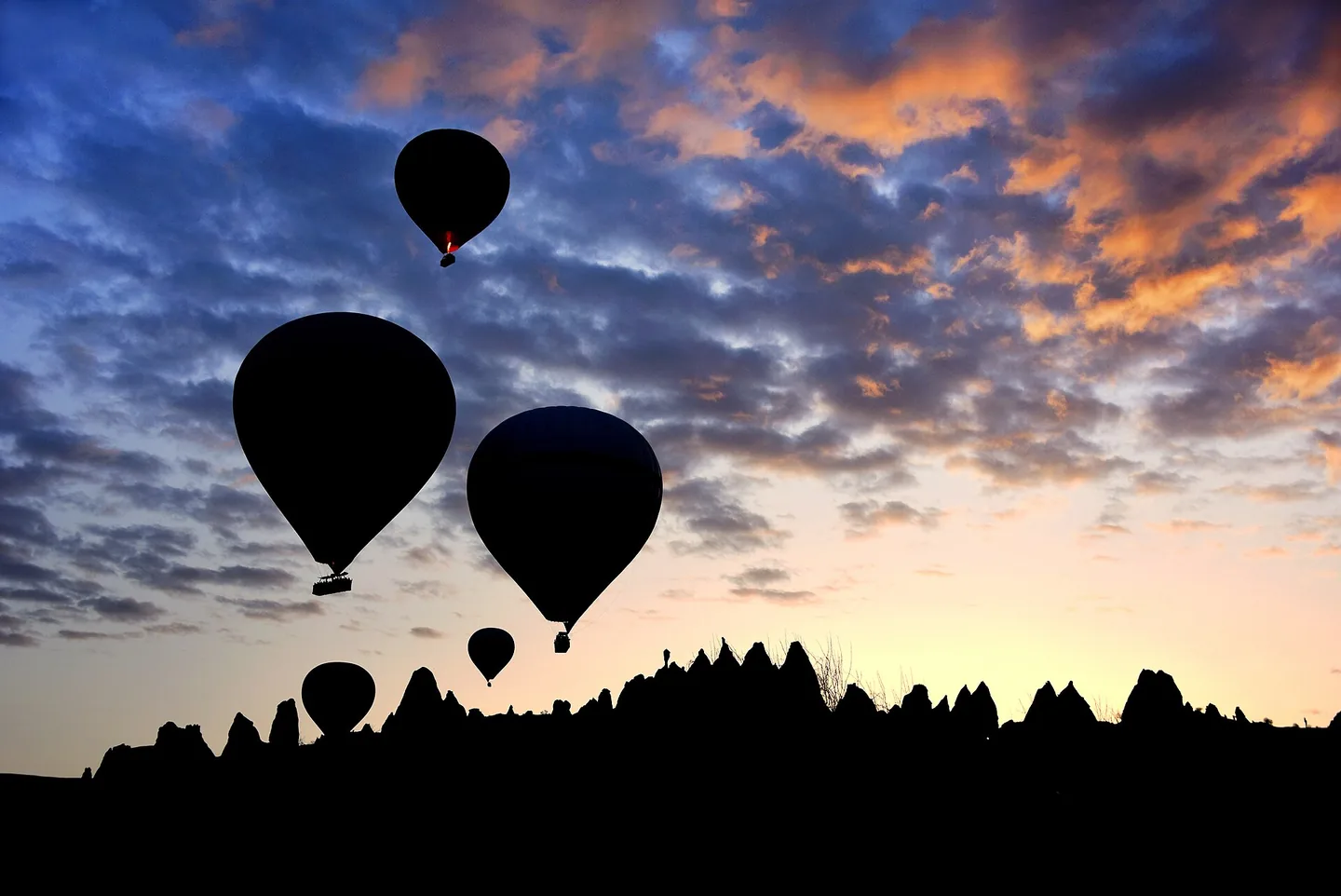 Hot-air balloons over the rock formations of Cappadocia, Türkiye